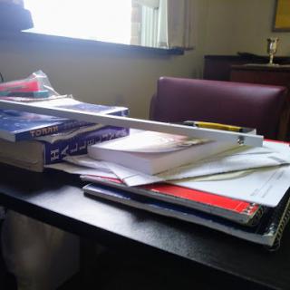 A cluttered desk filled with various study materials and books.