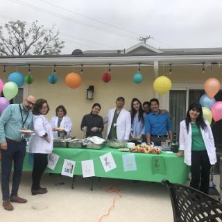 A lively outdoor gathering featuring food and fun, adorned with colorful balloons.