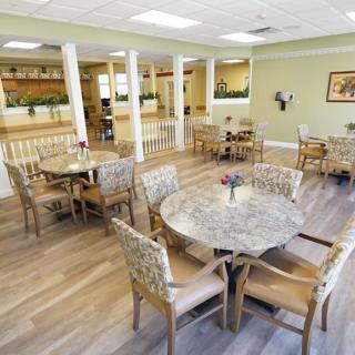 A spacious dining area with round tables and upholstered chairs.