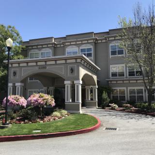 A well-maintained residential building with landscaped gardens and a covered entrance.
