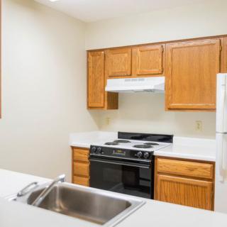 A modern kitchen featuring wooden cabinets and a range of appliances.