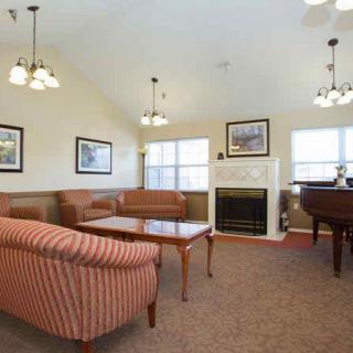 A cozy living room with sofas, a fireplace, and large windows.