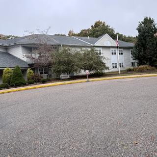 A view of a residential building surrounded by trees on a cloudy day.