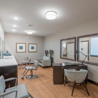 A modern salon interior featuring stylish furniture and ample lighting.