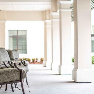 A peaceful corridor with outdoor seating and elegant columns.