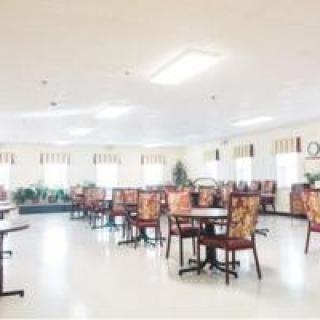 A bright and spacious dining room with neatly arranged tables and chairs.
