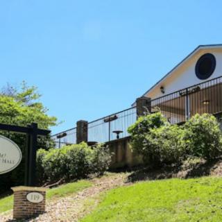 A scenic view of a building with surrounding greenery and a clear blue sky.