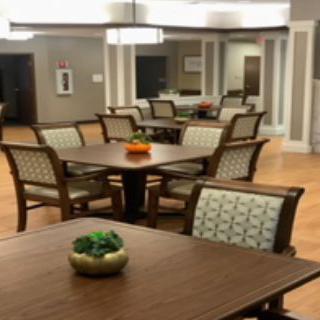 A well-lit dining area with multiple tables and chairs, arranged elegantly.
