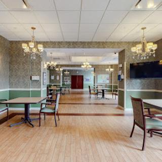 A spacious and elegantly designed dining area featuring tables, chairs, and chandeliers.