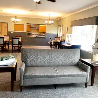 A cozy living room with a grey sofa facing an open dining area.