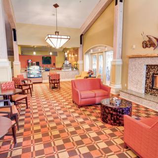 A cozy lounge area with comfortable seating, a fireplace, and decorative lighting.