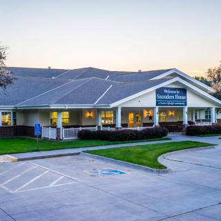 A healthcare facility featuring a large parking lot and well-maintained landscape during the evening.