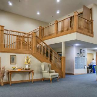 A welcoming lobby with a wooden staircase and comfortable seating area.