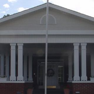 A symmetrical building entrance with columns and a porch.