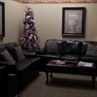 A cozy waiting room with a Christmas tree and comfortable seating.