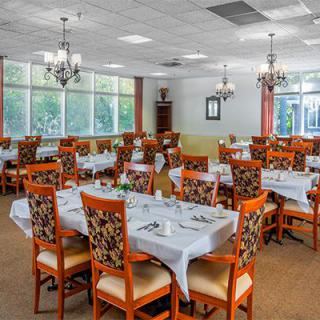 A spacious dining room with elegantly set tables and comfortable chairs.