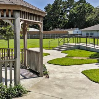 A peaceful garden with a gazebo and winding walkways surrounded by greenery.