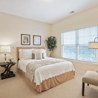 A cozy and elegantly designed bedroom featuring a comfortable bed, stylish decor, and abundant natural light.