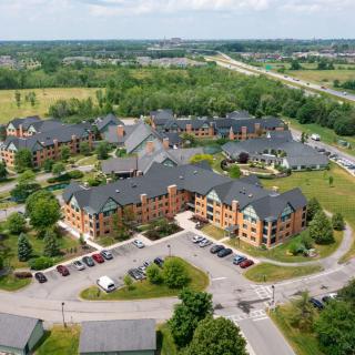 Aerial view of a residential complex surrounded by greenery and roads.