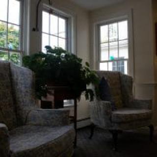 A cozy living room with plush chairs and large windows letting in natural light.