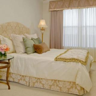 A luxurious bedroom decorated with elegant furnishings including a plush bed, decorative pillows, and a stylish lamp.