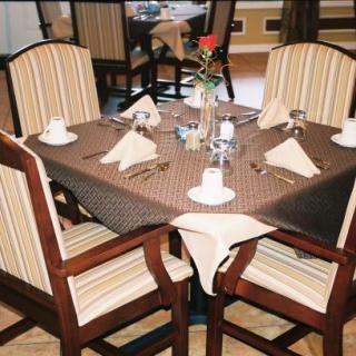 A neatly set dining table with striped chairs in a restaurant.