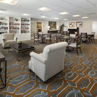 A spacious lounge area featuring comfortable seating, bookshelves, and elegant decor.