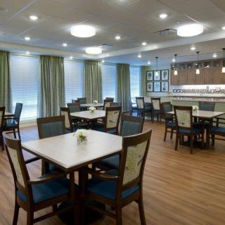 A spacious and elegantly designed dining room with neatly arranged tables and chairs.