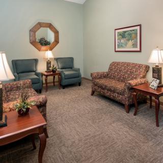 A cozy living room with sofas, armchairs, and decorative lamps.