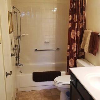 A cozy bathroom with a shower-tub combination and floral shower curtain.