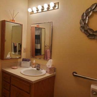 A cozy bathroom with a wooden vanity and decorative elements.