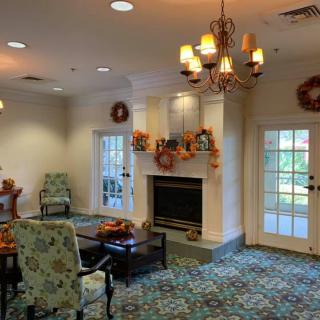 A cozy living room with a fireplace and fall-themed decorations.