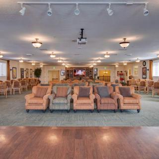 A spacious lounge area with rows of comfortable chairs and warm lighting.