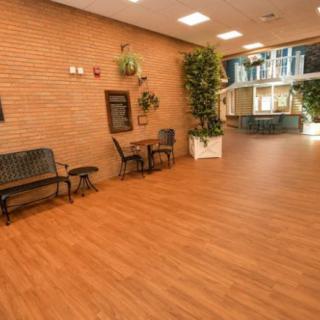 A spacious indoor lobby with seating, tables, and decorative plants.
