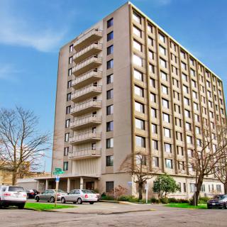 A multi-story apartment building with balconies in an urban setting.