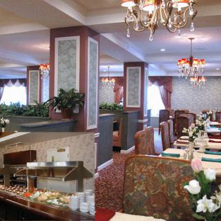 An elegant dining area featuring chandeliers, plush booths, and a buffet setup.