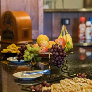 A variety of fruits and snacks are displayed on a kitchen countertop.