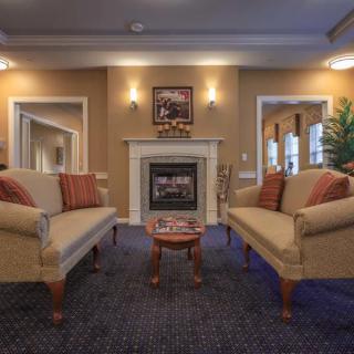A cozy traditional-style living room with two sofas facing a fireplace.