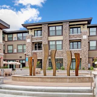 A modern apartment complex featuring a unique sculptural fountain in its courtyard.