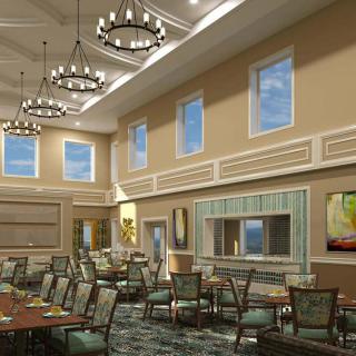A spacious dining area with elegant chandeliers and high ceilings, featuring a variety of seating and large windows.
