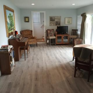 A cozy living room with a piano, television, and various pieces of furniture.