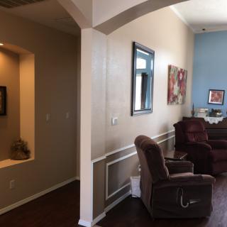 A cozy living room featuring recliner chairs and wall art.
