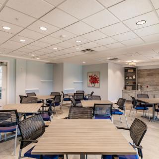 A modern office cafeteria with tables and chairs arranged for seating.
