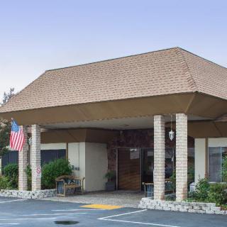 The entrance of a building with columns and an American flag displayed.