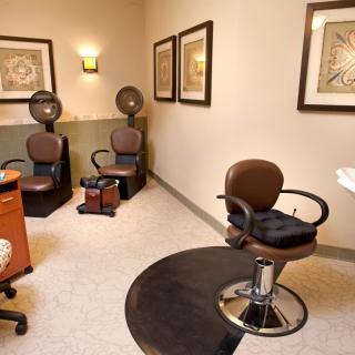 A cozy hair salon interior featuring styling chairs and hair dryers.