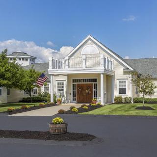 A charming residential building with a well-maintained lawn and driveway.