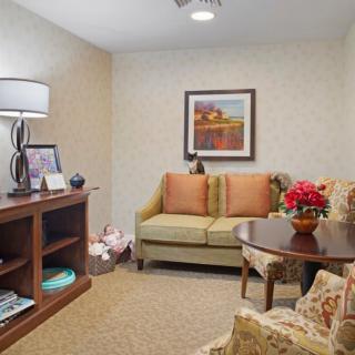 A cozy living room with a sofa, decorative pillows, and a small table with flowers.