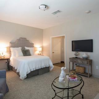A modern bedroom with a comfortable bed, TV, and stylish decor.