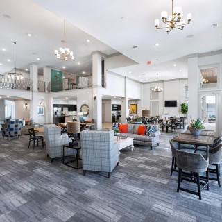 A modern and spacious lobby with elegant furniture and chandeliers.