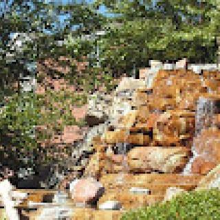 A serene waterfall cascading over rocky formations, surrounded by lush greenery.